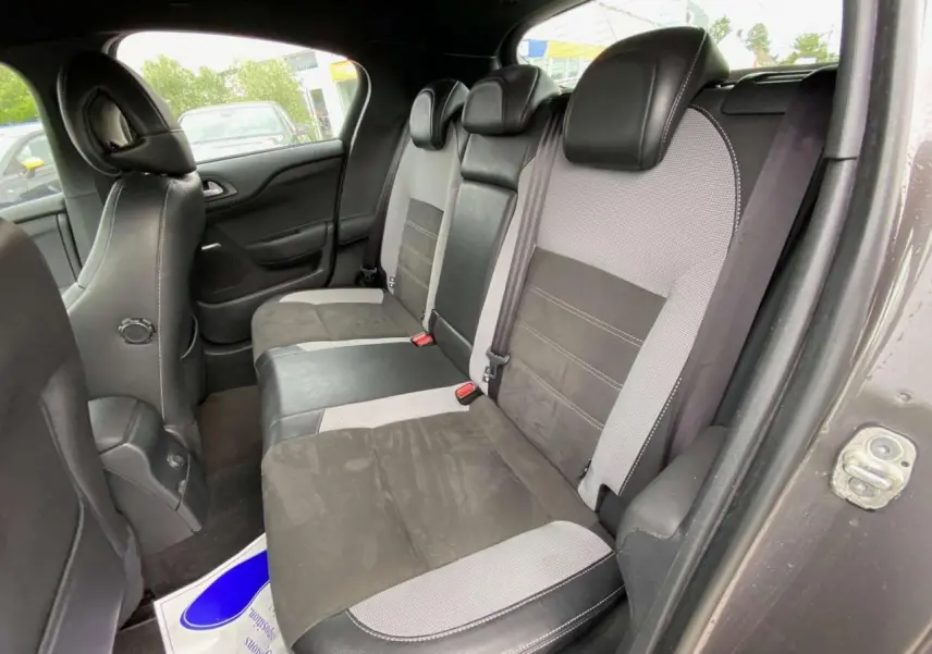 Vue intérieure des sièges arrière bi-matière gris clair et noir d'une DS4 2016, avec ceinture de sécurité et appuie-têtes.