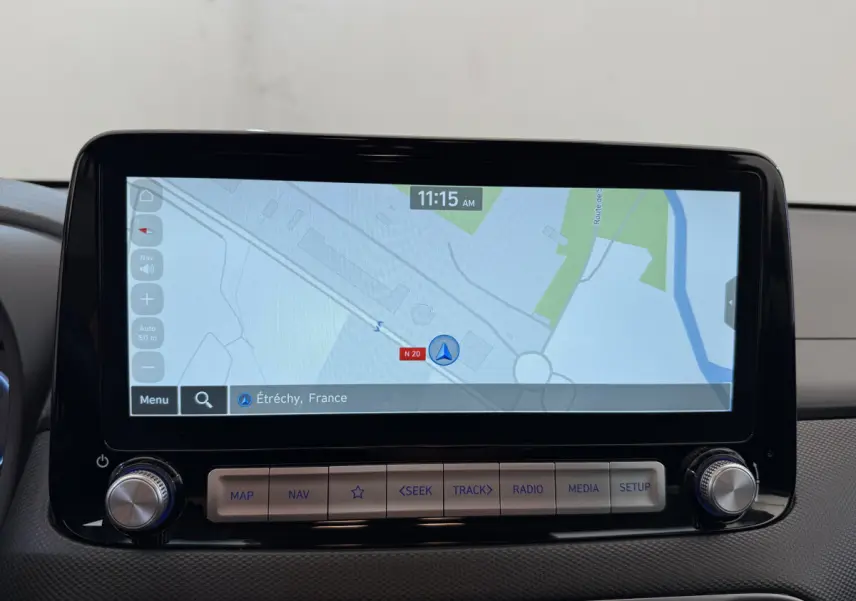 Écran tactile central affichant la navigation GPS dans un Hyundai Kona électrique gris clair, vue intérieure frontale.
