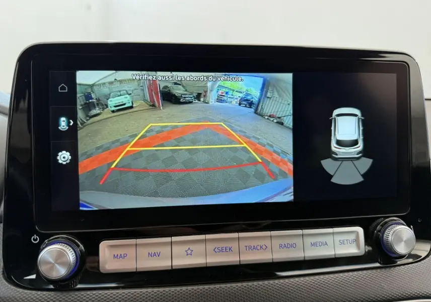 Écran tactile central du Hyundai Kona gris clair 2022 montrant la caméra de recul et l'aide au stationnement arrière.