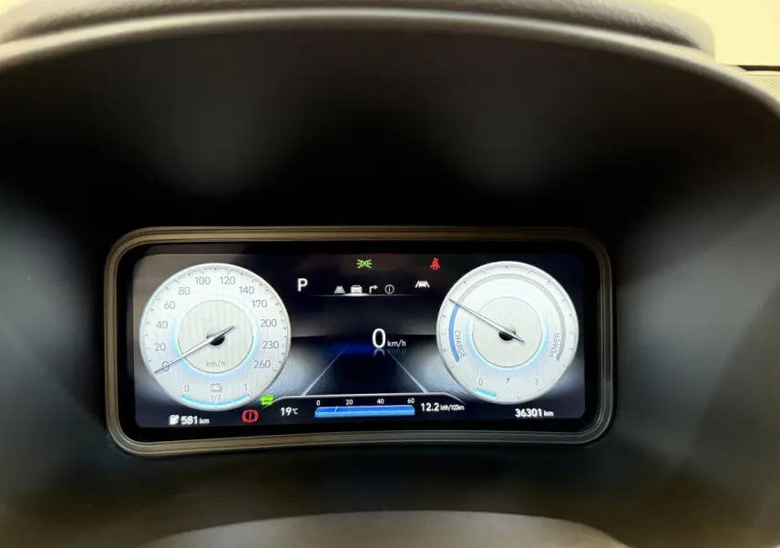 Gros plan sur le tableau de bord numérique du Hyundai Kona électrique 2022, affichant vitesse, autonomie et indicateurs.