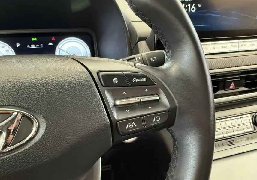 Gros plan sur le volant cuir et les commandes multifonctions du tableau de bord du Hyundai Kona gris clair électrique 2022.