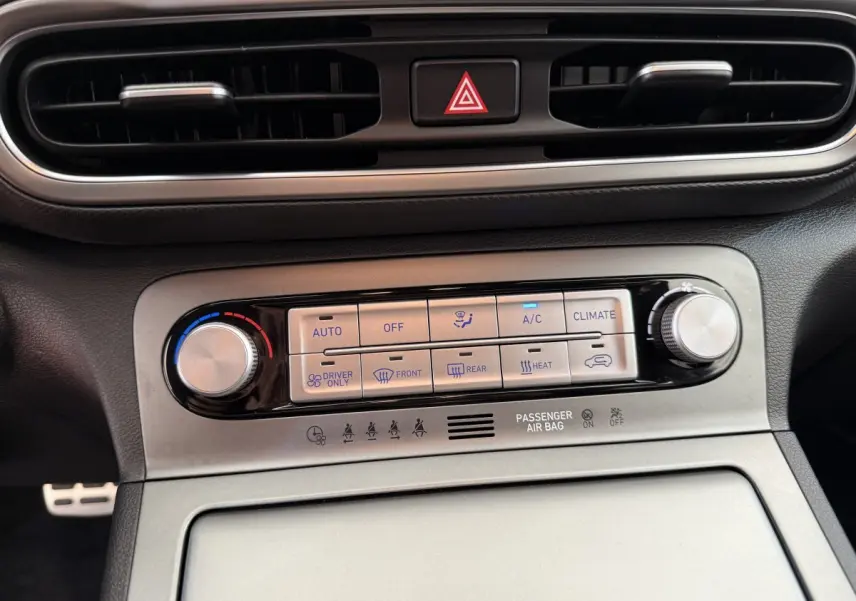 Gros plan sur la commande de climatisation argentée et noire du tableau de bord du Hyundai Kona gris clair 2022 électrique.