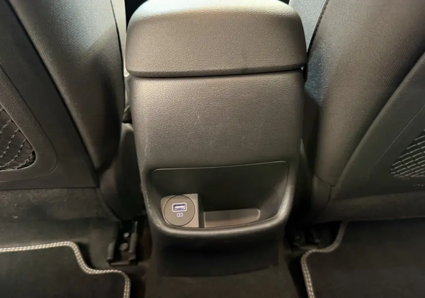 Prise USB arrière et rangement central dans l'habitacle noir du Hyundai Kona électrique gris clair 2022.