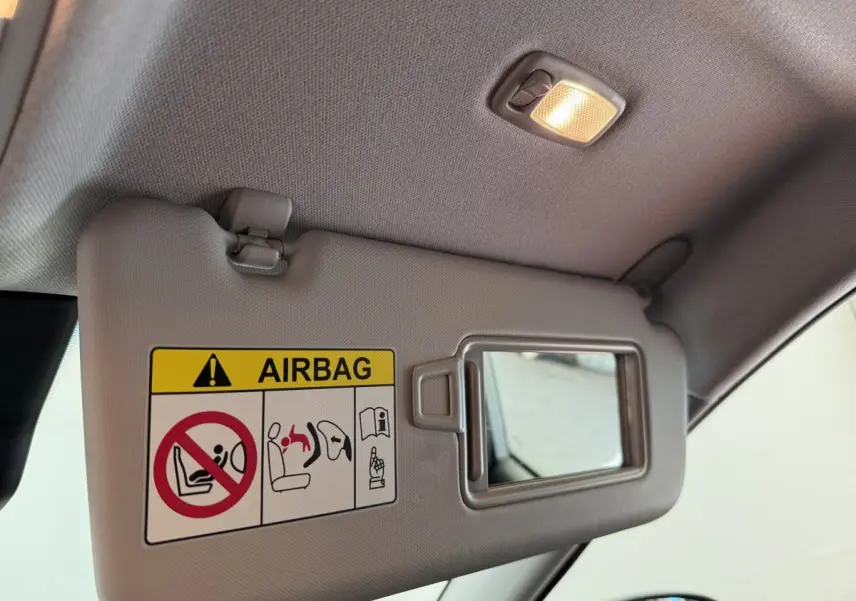 Détail du pare-soleil gris clair côté conducteur du Hyundai Kona 2022 avec miroir et avertissement airbag.