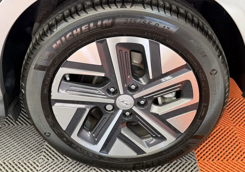 Gros plan sur la jante alliage et pneu Michelin du Hyundai Kona électrique gris clair, détail du design moderne.