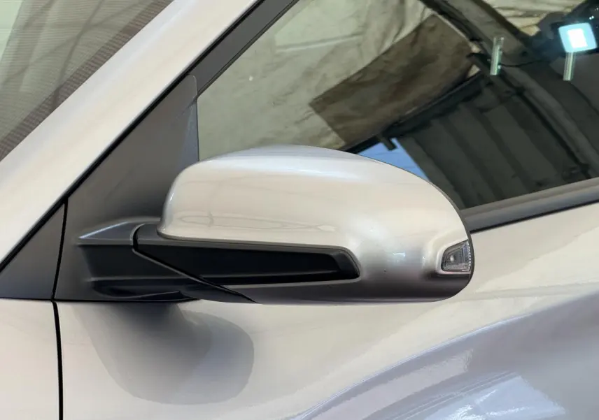 Rétroviseur côté conducteur gris clair du Hyundai Kona électrique 2022 avec clignotant intégré, vue rapprochée.