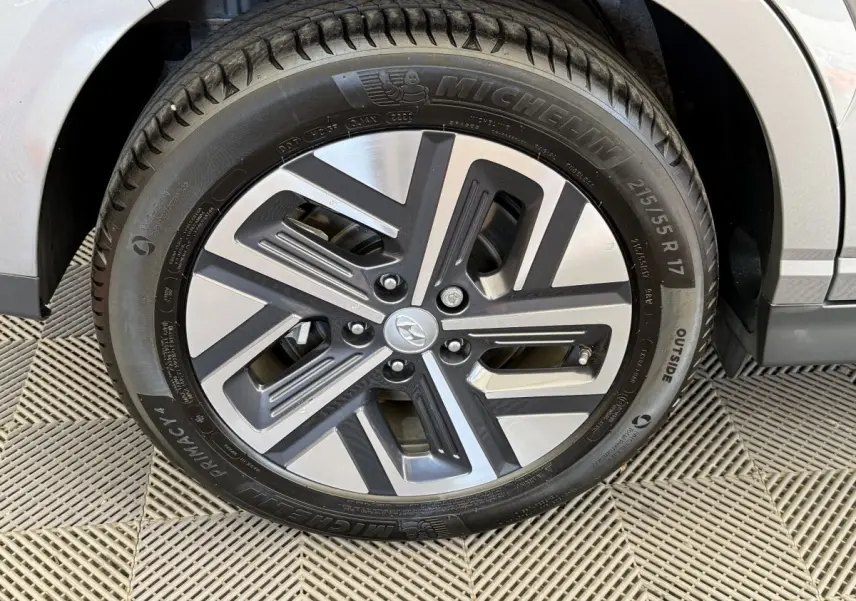 Gros plan sur la jante alliage gris et noir du Hyundai Kona électrique gris clair, avec pneu Michelin visible.