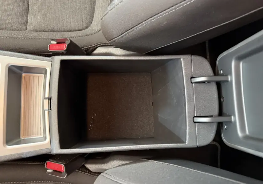 Vue plongeante sur le rangement central ouvert entre les sièges avant du Hyundai Kona gris clair électrique 2022.