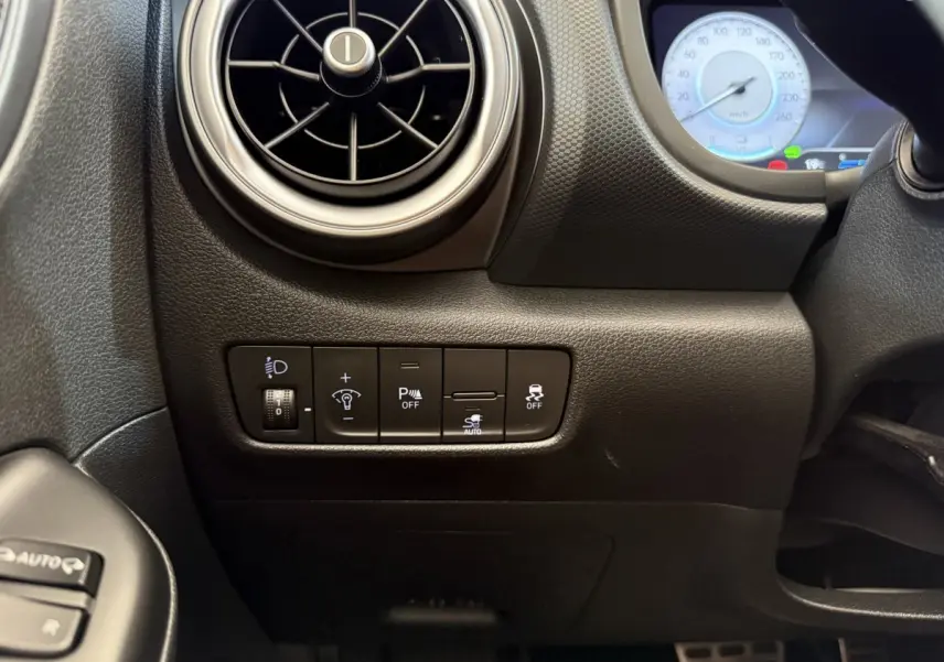 Détail du tableau de bord noir côté gauche du Hyundai Kona électrique 2022 avec commandes d'éclairage et ventilation ronde.
