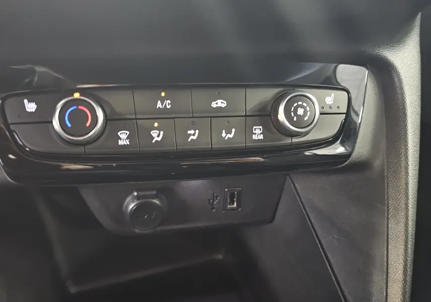Vue rapprochée de la console centrale de l’Opel Corsa 2022, avec commandes de climatisation et ports USB visibles.