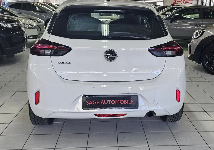 Vue arrière d'une Opel Corsa blanche glacier 5 portes de 2022, avec feux arrière sombres et logo central visible.