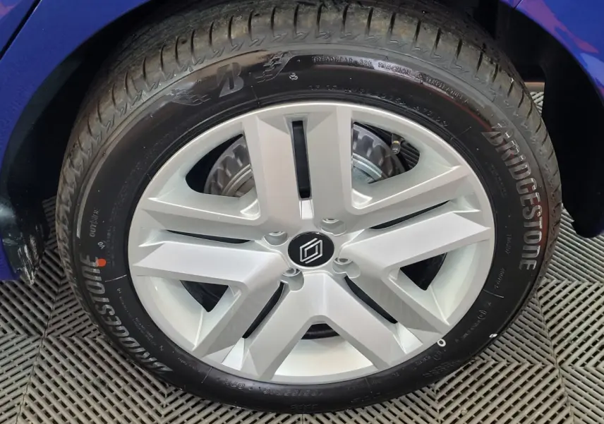 Gros plan sur la roue arrière droite d'une Renault Clio bleu 2025 avec pneu Bridgestone visible.