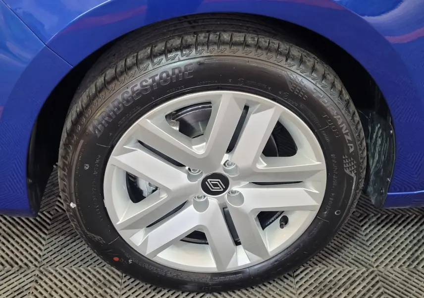 Gros plan sur la roue avant gauche d'une Renault Clio bleu 2025 avec jante argentée au design moderne.