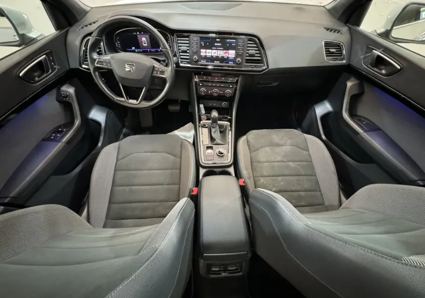 Vue intérieure avant du SEAT Ateca 2019, montrant tableau de bord digital, volant cuir, et sièges gris foncé.