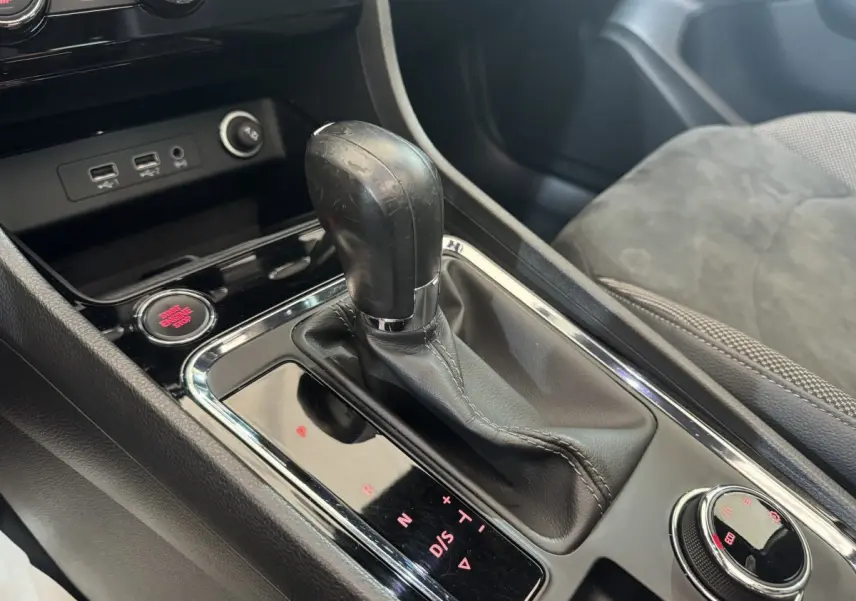 Gros plan sur la console centrale de la SEAT Ateca gris clair, mettant en valeur le levier de vitesses automatique et le bouton start-stop rouge.