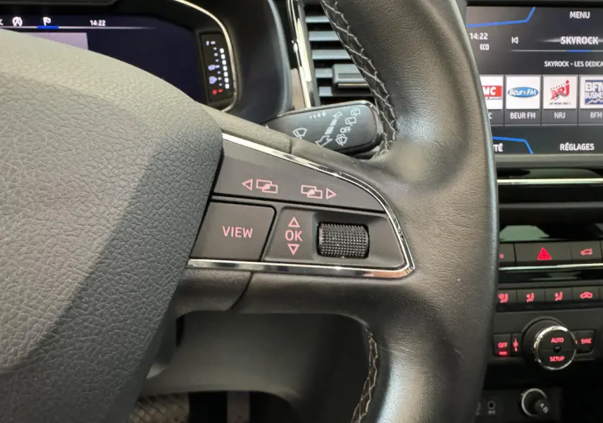 Gros plan sur le volant cuir noir de la SEAT Ateca 2019 avec commandes intégrées et écran tactile en arrière-plan