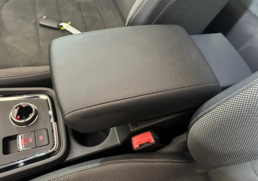 Détail de l'accoudoir central noir et console avec commandes électroniques dans l'habitacle du SEAT Ateca gris clair.