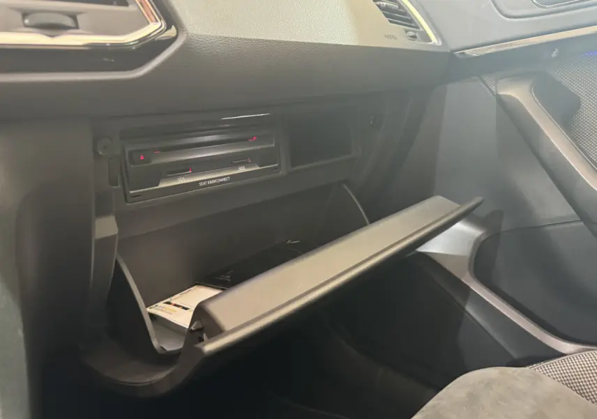 Ouverture de la boîte à gants côté passager dans l'habitacle noir du SEAT Ateca gris clair 2019.