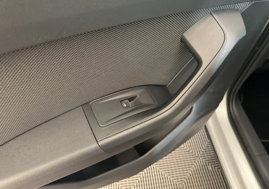Détail de la poignée intérieure et commande de lève-vitre côté conducteur d'un SEAT Ateca gris clair.
