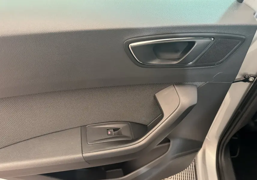 Intérieur de la porte côté conducteur du SEAT Ateca gris clair, avec poignée et commande de vitre électrique.
