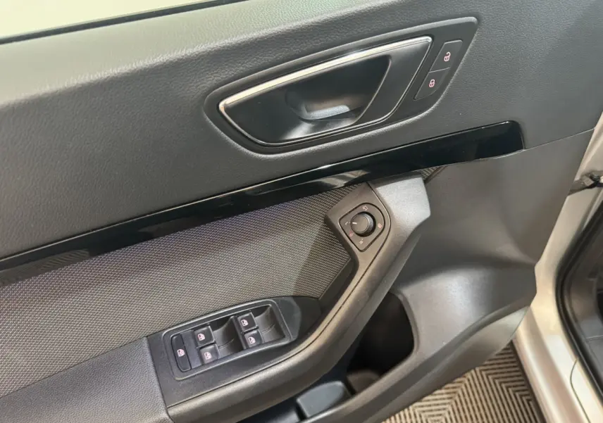 Poignée intérieure côté conducteur avec commandes des vitres et rétroviseurs du SEAT Ateca gris clair 2019.