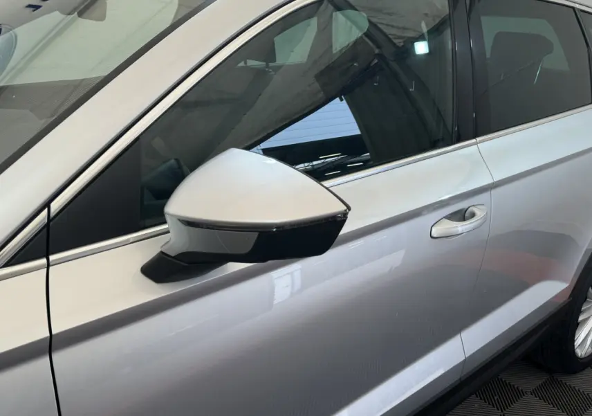 Détail du rétroviseur côté gauche gris clair du SEAT Ateca 2019 avec poignée de porte visible en arrière-plan.