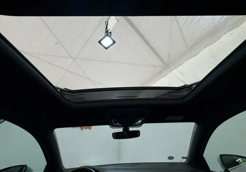 Toit ouvrant panoramique ouvert vu de l'intérieur avant du SEAT Ateca gris clair 2019 avec rétroviseurs visibles