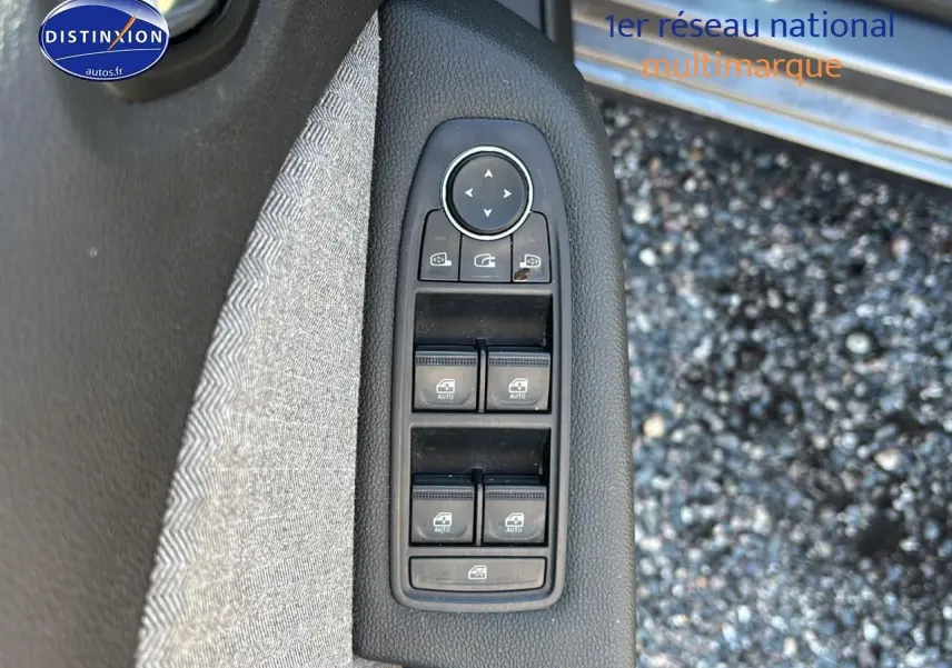 Commandes des vitres électriques et rétroviseurs sur la porte côté conducteur d'une Renault Clio V gris pizarra.