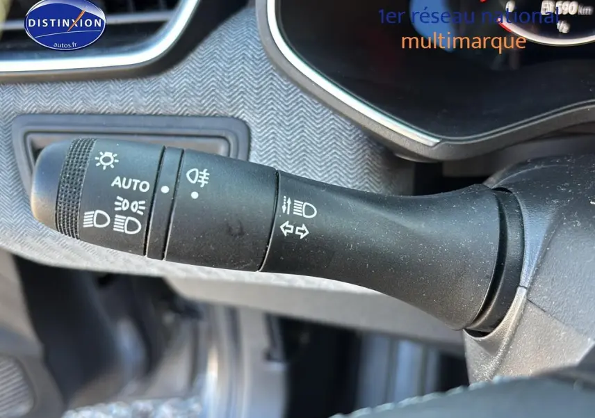 Gros plan sur la commande des phares et clignotants dans l'habitacle d'une Renault Clio V gris Pizarra.