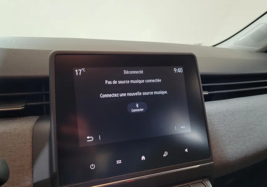 Écran tactile central de la Renault Clio bleu 2025 affichant un message de connexion Bluetooth, intérieur clair.