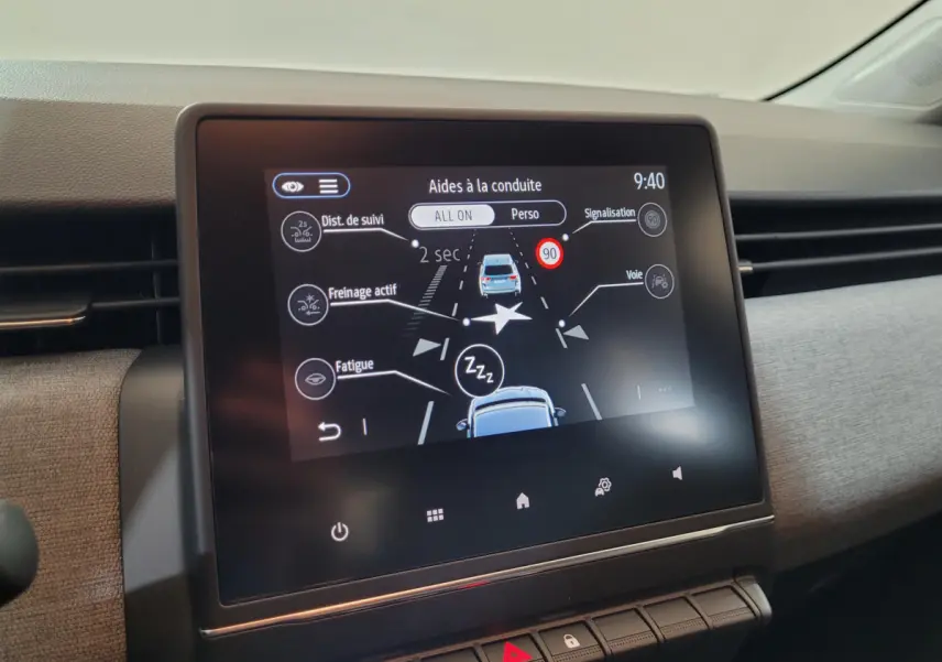 Écran tactile central de la Renault Clio bleu 2025 affichant les aides à la conduite en intérieur.