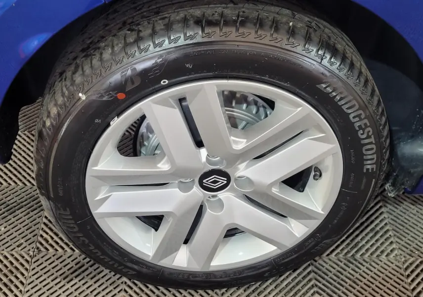 Gros plan sur la roue avant droite de la Renault Clio bleu avec jante argentée et pneu Bridgestone.