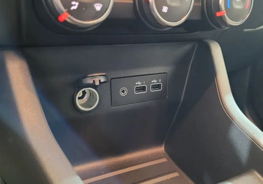 Prise 12V et double port USB intégrés dans la console centrale noire de la Renault Clio Evolution Blue dCi 100 2025.