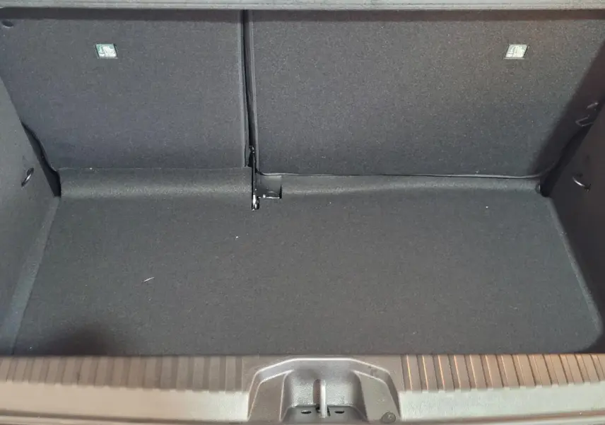 Coffre ouvert vu de face de la Renault Clio bleu, montrant l'espace de chargement avec banquette arrière rabattue.