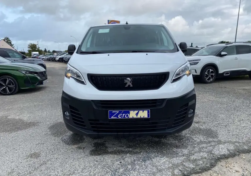 Vue frontale d'un Peugeot Expert Fourgon blanc 2023 avec calandre noire et plaque Zero KM visible.