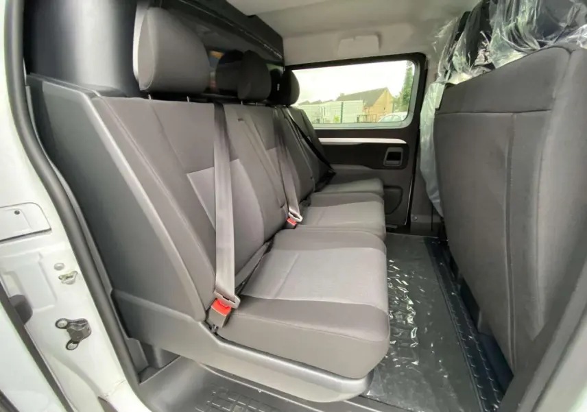 Vue intérieure côté droit du Peugeot Expert Fourgon blanc 2023, banquette arrière grise trois places avec ceintures de sécurité.