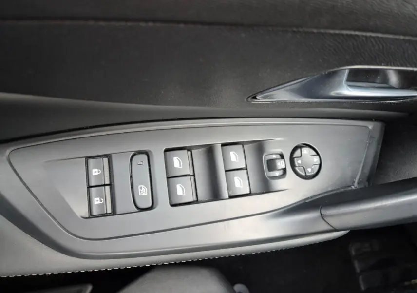 Panneau de commandes des vitres et rétroviseurs électriques côté conducteur dans une Peugeot 308 2024 finition Allure.