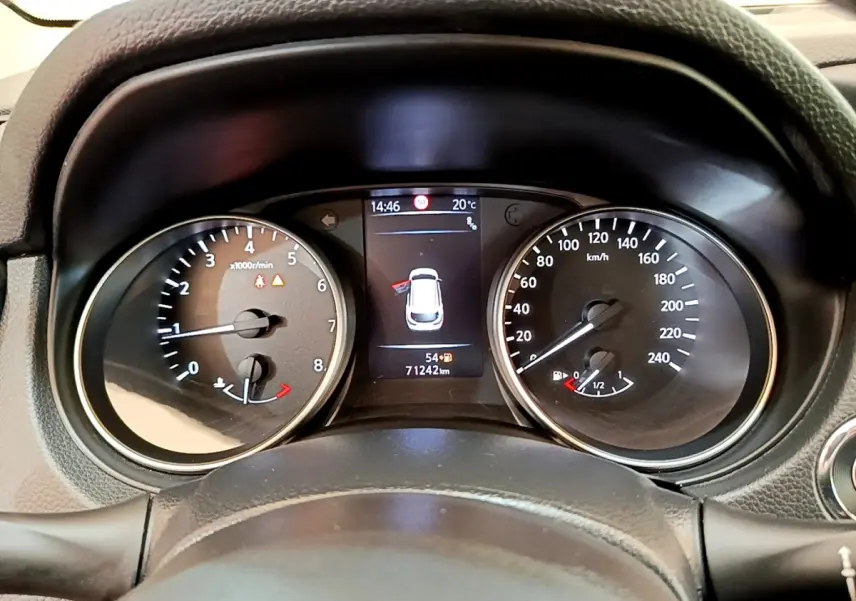 Vue rapprochée du tableau de bord du Nissan Qashqai blanc, affichant compte-tours, vitesse et écran central numérique.
