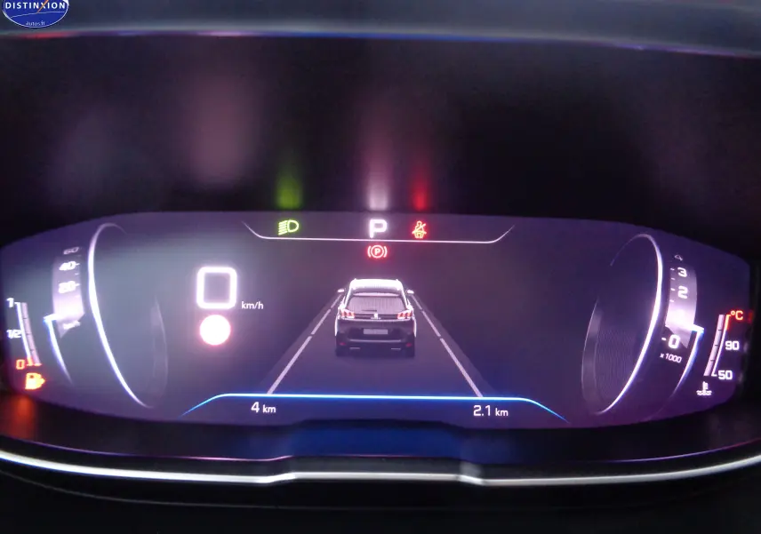 Affichage numérique du tableau de bord du Peugeot 5008 2023 montrant la voiture vue de dos en mode parking, avec indicateurs de vitesse et température.