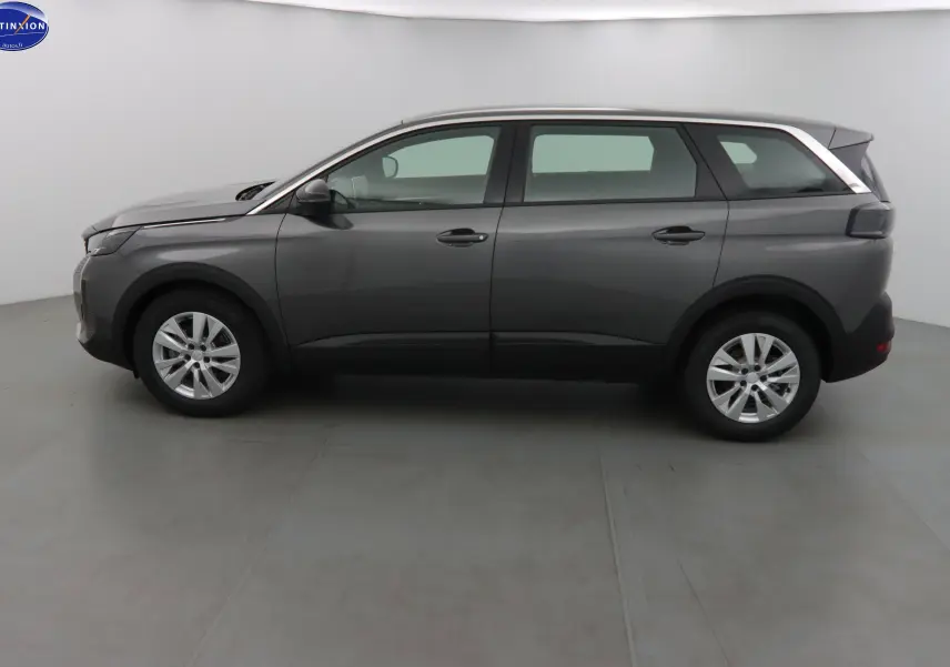 Profil côté gauche d'un Peugeot 5008 gris platinium métal 2023 avec jantes alliage et toit contrasté blanc.