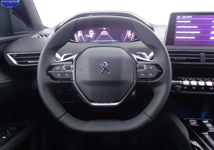 Volant cuir noir au centre du tableau de bord du Peugeot 5008 gris platinium, avec écran digital et commandes intégrées.