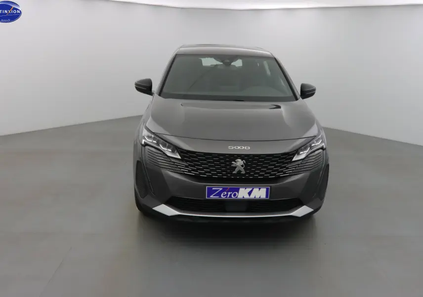 Vue frontale d'un Peugeot 5008 gris platinium métal 2023 avec calandre noire et phares LED distinctifs.