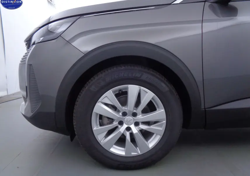 Gros plan sur la roue avant gauche du Peugeot 5008 gris platinium métal, mettant en valeur la jante alliage et le pneu Michelin.