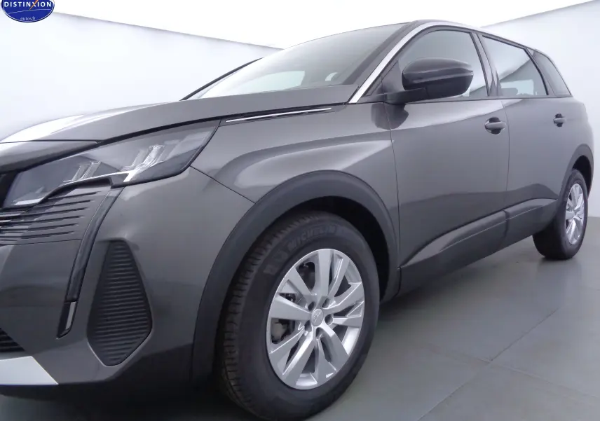 Peugeot 5008 gris platinium métal vue 3/4 avant droit mettant en valeur ses phares LED et jantes alliage.