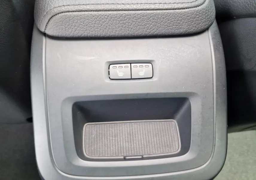 Gros plan sur la console centrale noire du Volvo XC60 II avec commandes des sièges chauffants arrière.