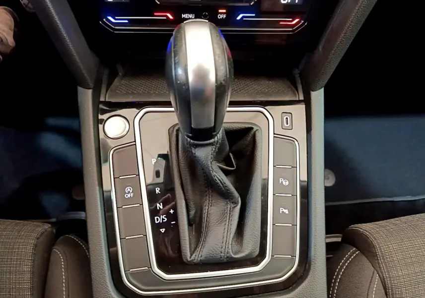 Le levier de vitesses automatique noir et argenté de la Volkswagen Passat gris foncé, vu de dessus au centre de la console.