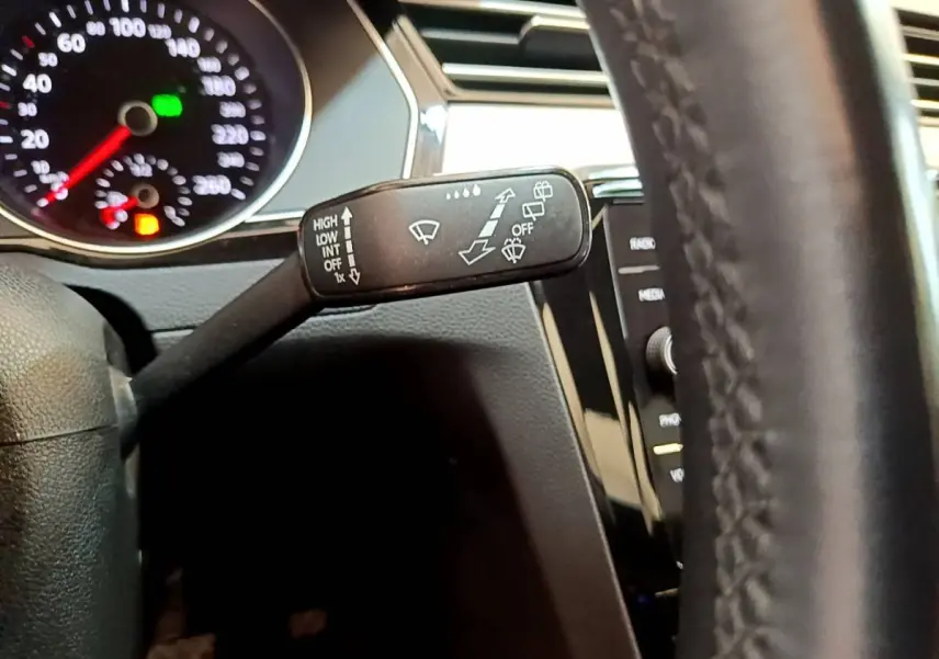 Gros plan sur la manette d’essuie-glace côté gauche du tableau de bord d’une Volkswagen Passat gris foncé 2021.