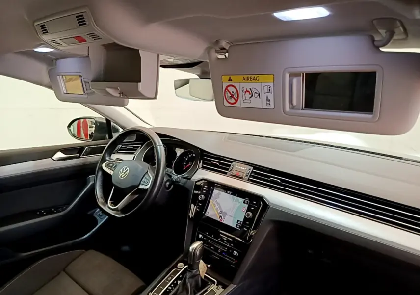 Intérieur avant droit de la Volkswagen Passat gris foncé 2021, avec tableau de bord moderne et écran tactile central.