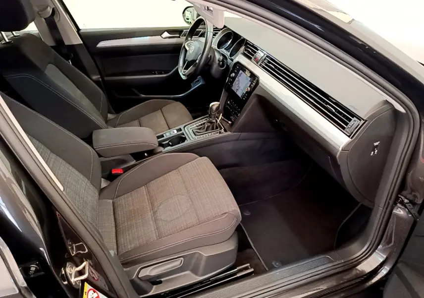 Intérieur avant droit d'une Volkswagen Passat gris foncé 2021 avec sièges tissu et écran tactile central.