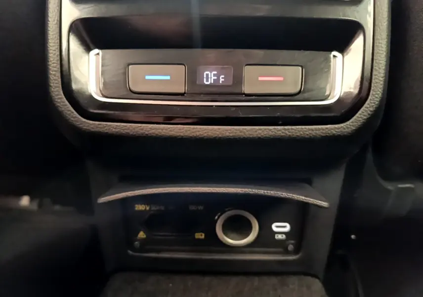 Vue rapprochée du panneau de commande de climatisation arrière et prises USB et 12V dans une Volkswagen Passat gris foncé 2021.